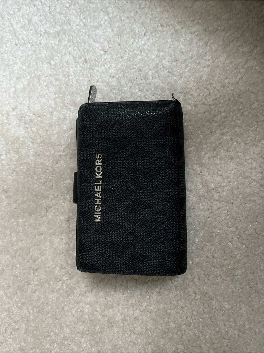 Michael Kors Black Pebbled Leather Zip-around wallet with silver tone lettering